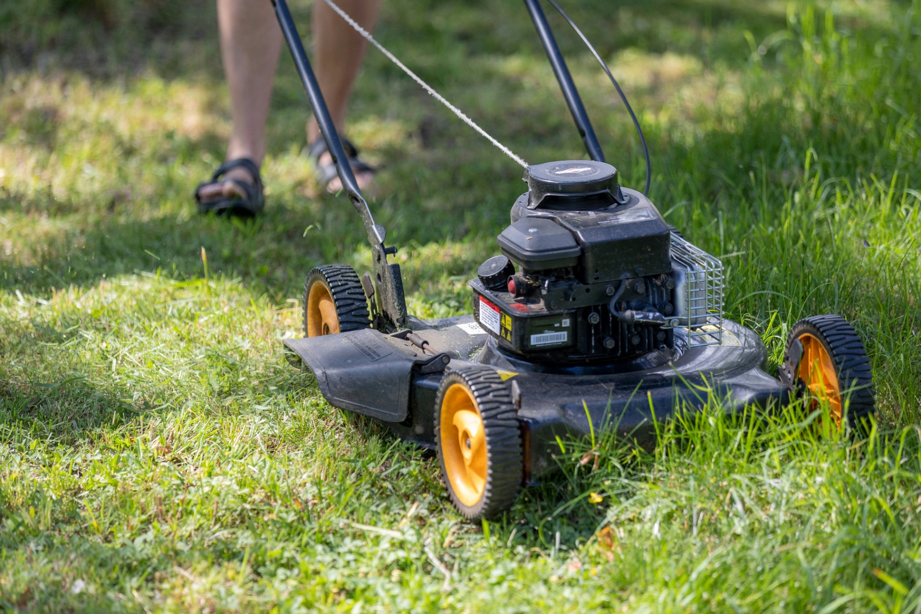 Commercial gas-powered lawn mower cutting grass on a GTA property
